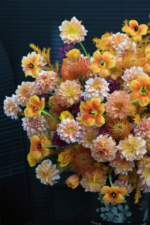 Free A vibrant bouquet of orange and yellow flowers with dark background, showcasing color contrast. Stock Photo