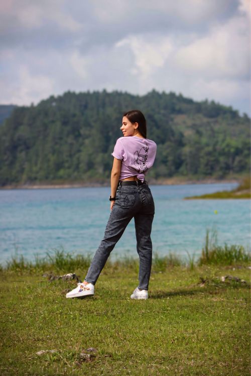 Free Woman stands by the lake in Mexico, wearing casual attire and enjoying nature. Stock Photo