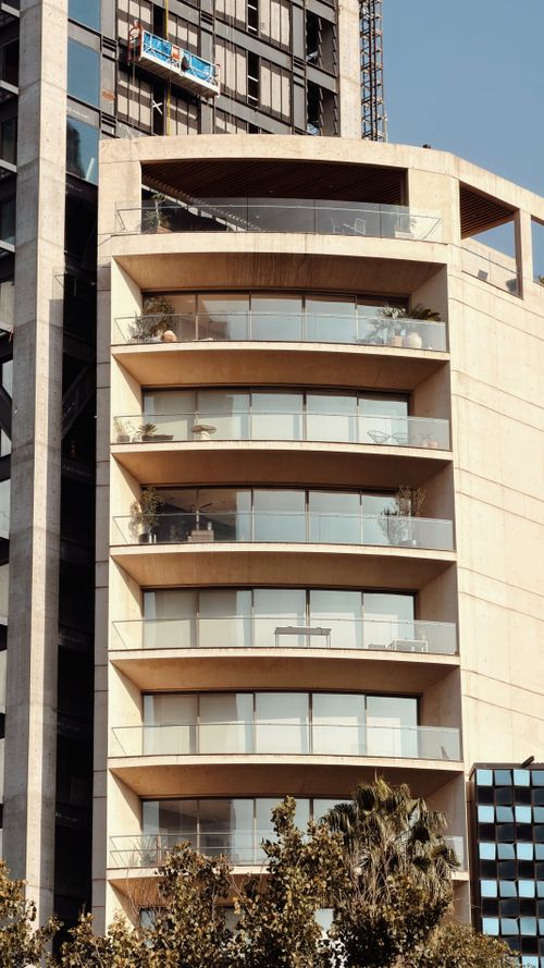 Free Close-up of a modern multi-story building facade with curved balconies under clear sky Stock Photo