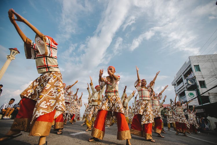 People In Gold And Red Traditional Dress Dancing On The Street