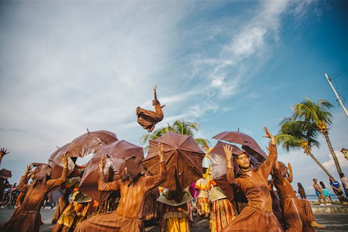 Люди в коричневой традиционной одежде под голубым небом