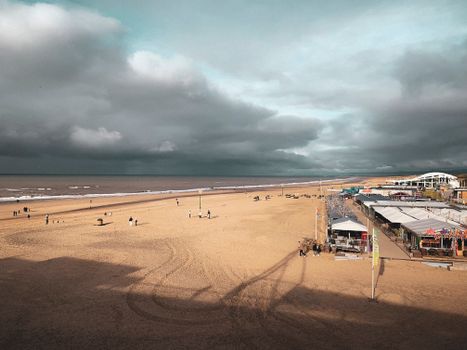A picturesque view of the beach in Den Haag, Netherlands with dramatic clouds.