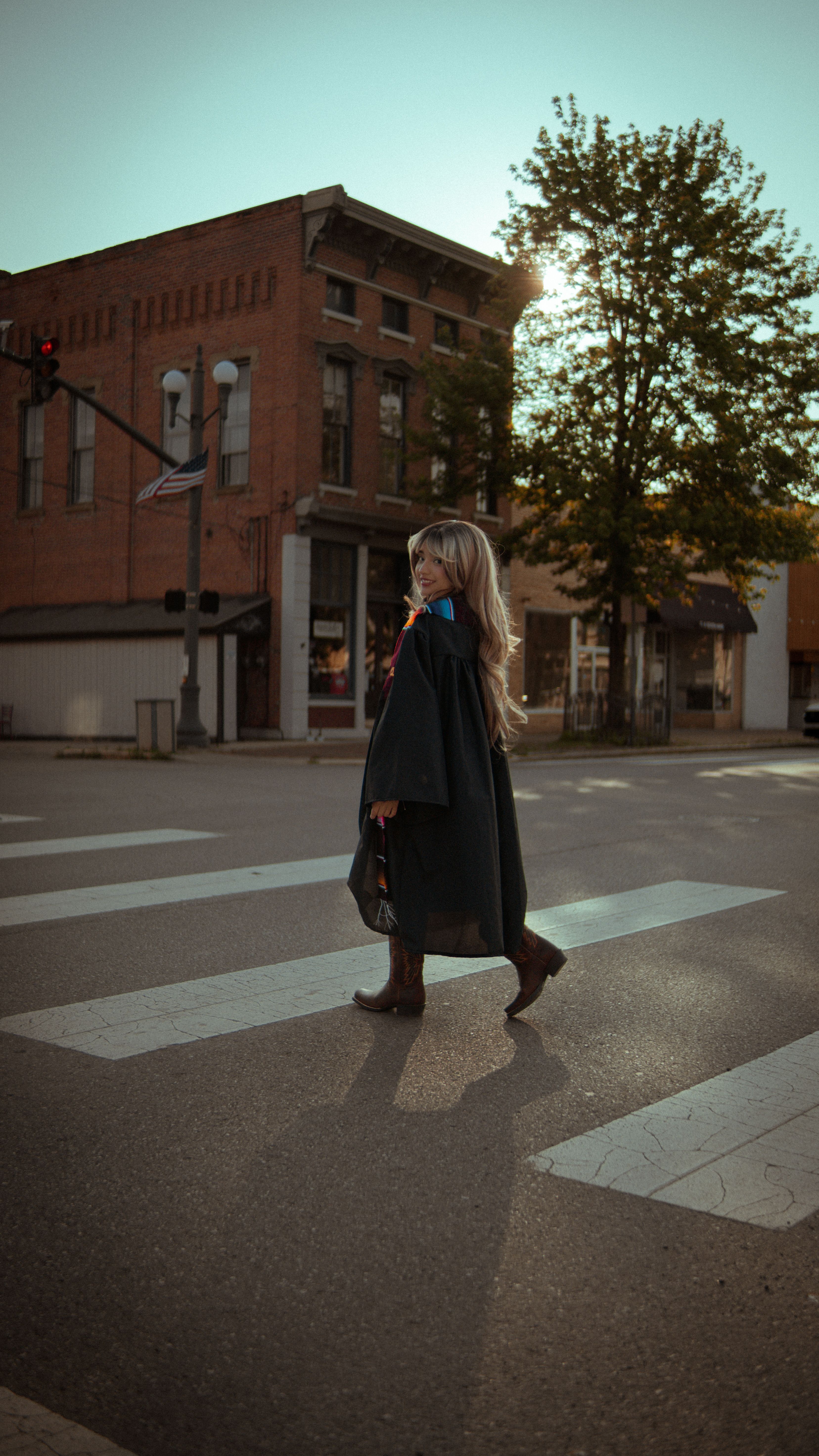 Woman in Graduation Gown Crossing City Street · Free Stock Photo