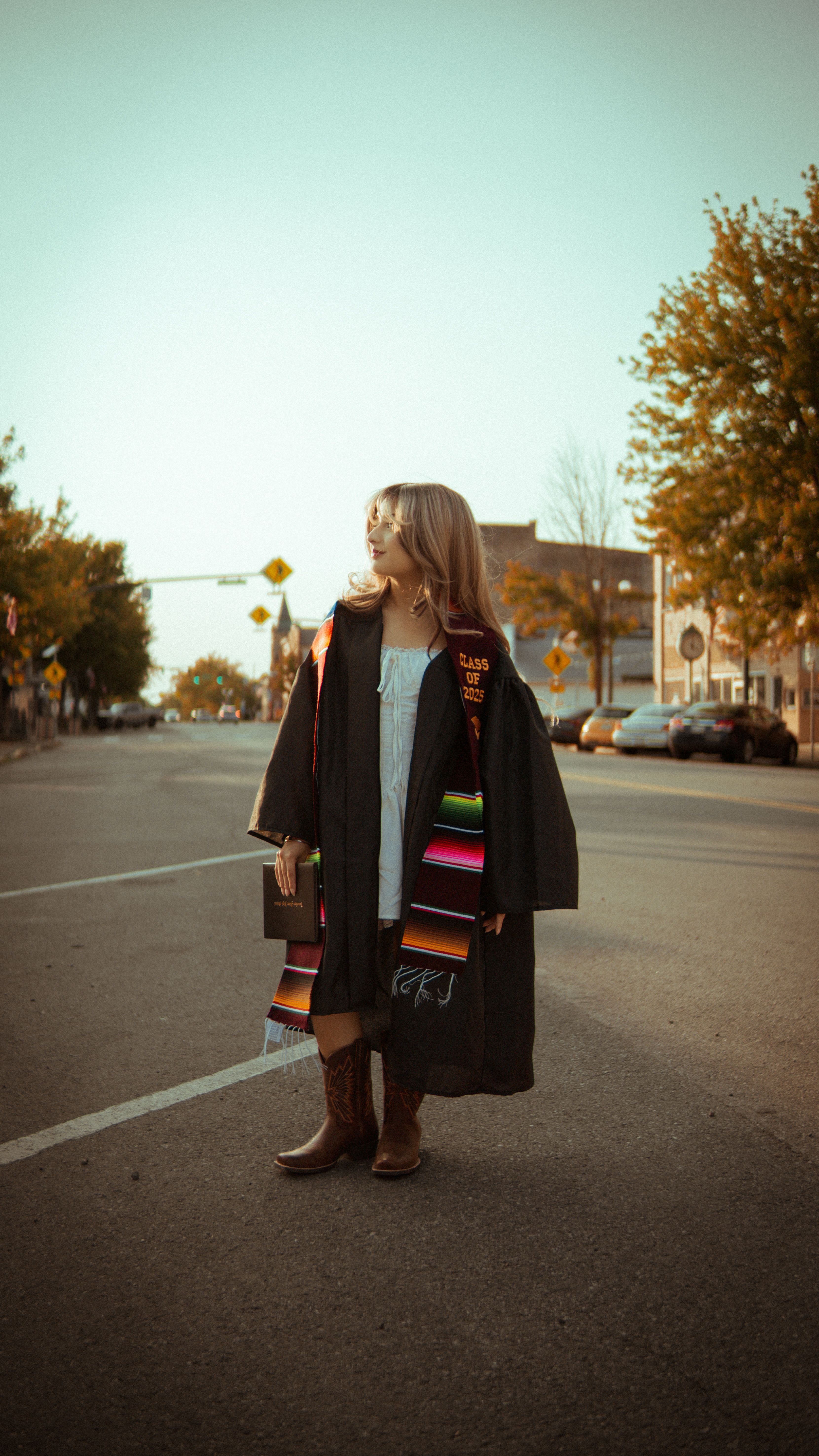 Young Graduate in Cap and Gown on Street · Free Stock Photo