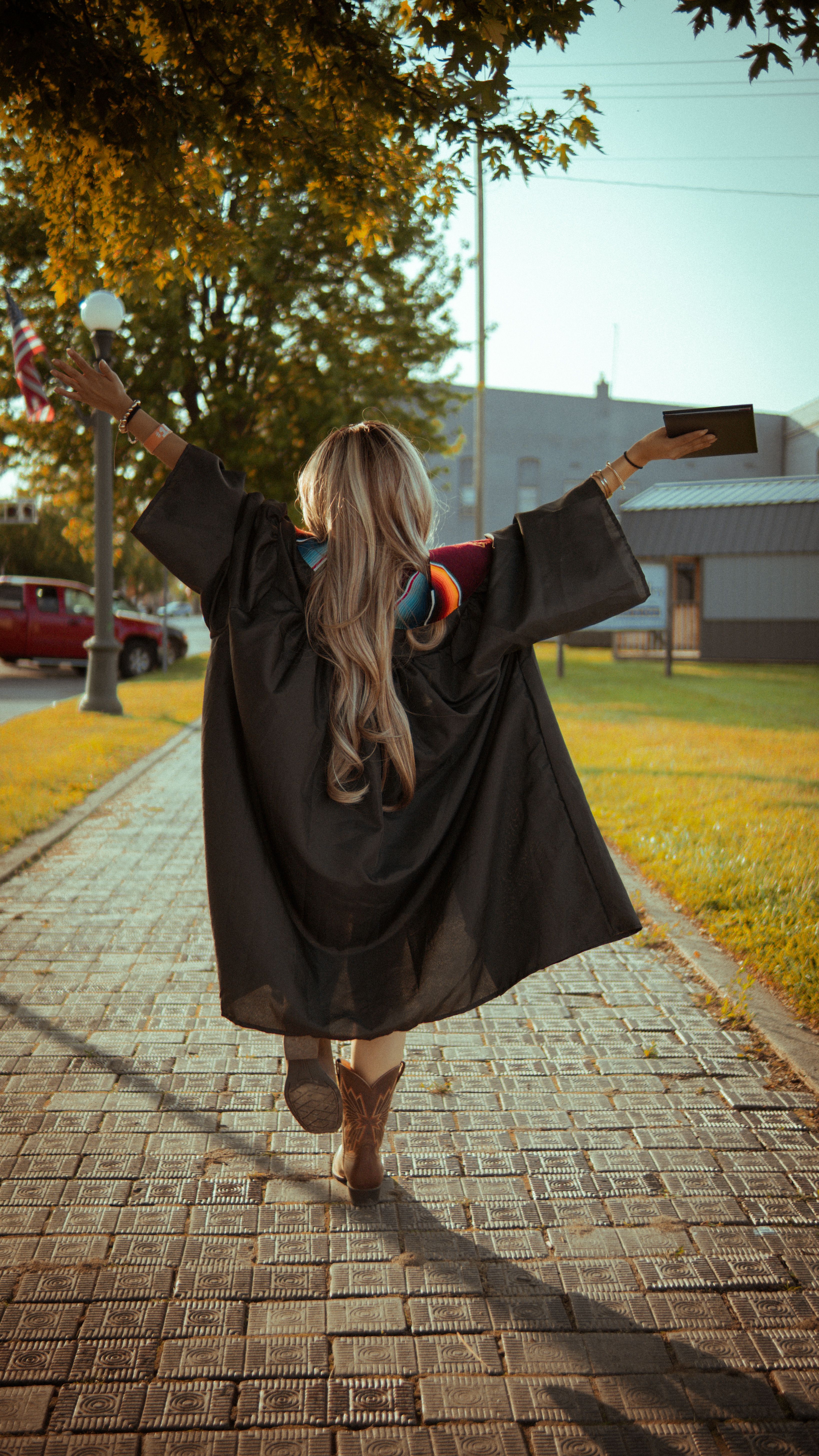 Joyful Graduate Celebrating in Cap and Gown Outdoors · Free Stock Photo
