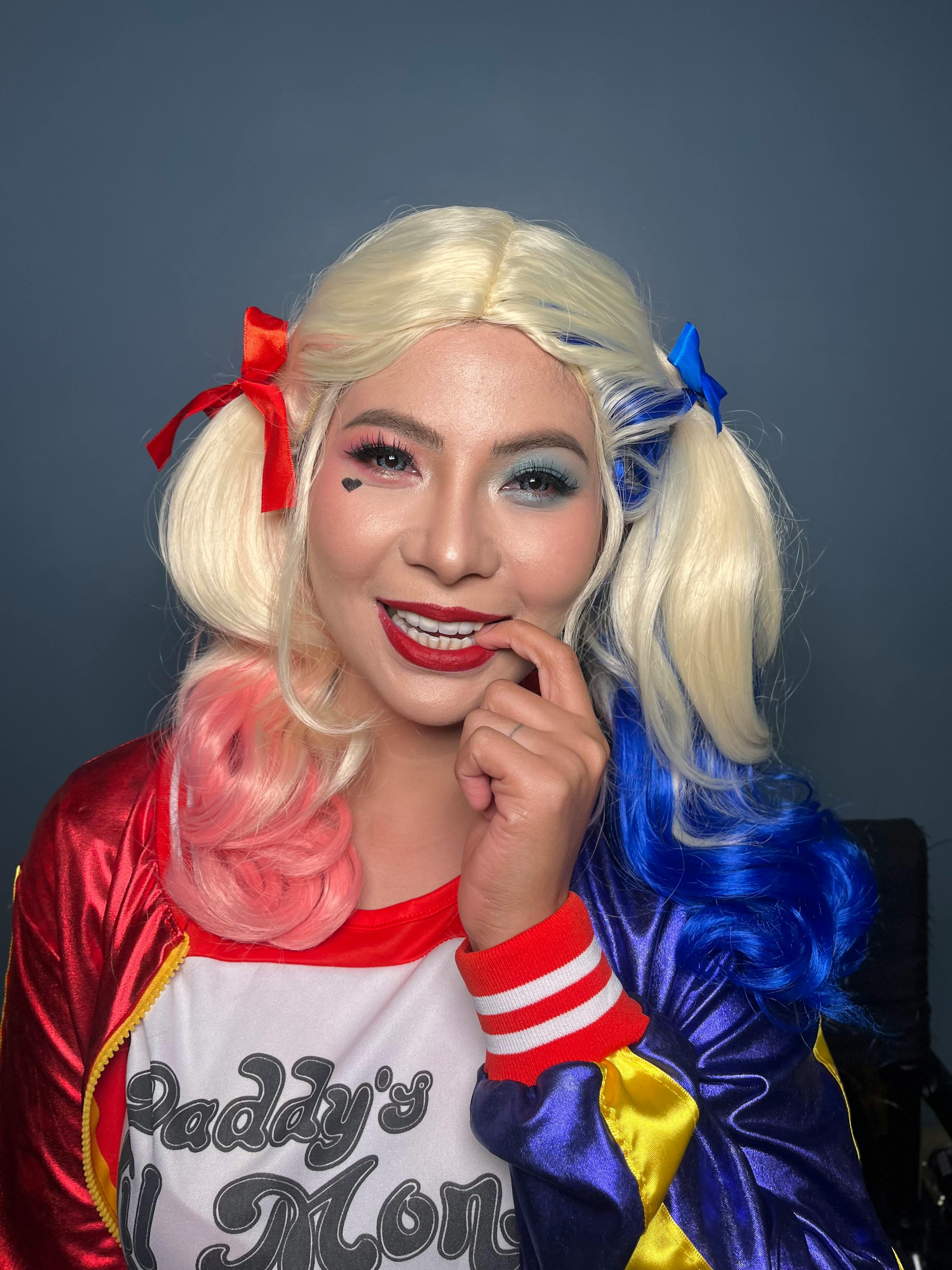Vibrant portrait of a person in costume with colorful wig and makeup.