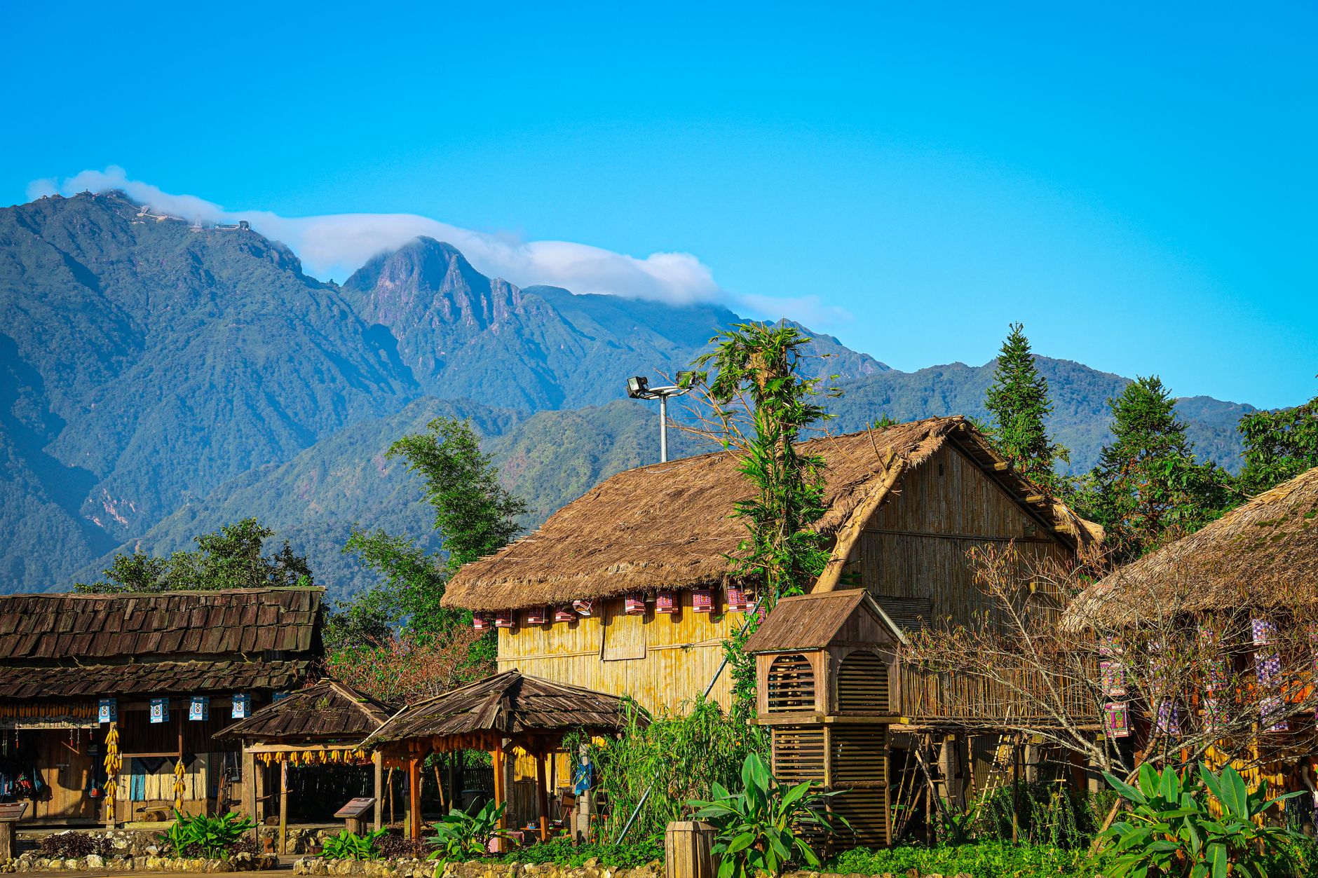 Scenic view of traditional thatched houses with mountains in Sapa, Vietnam.