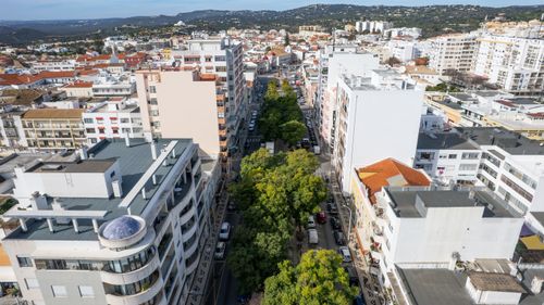 Free Aerial view over Loulé, Portugal, showcasing architecture and tree-lined streets under clear skies. Stock Photo