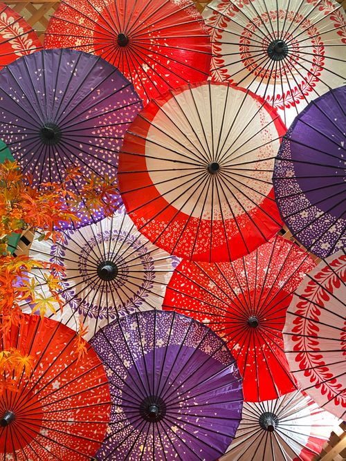Free Vibrant display of traditional Japanese paper umbrellas in various colors and patterns. Stock Photo