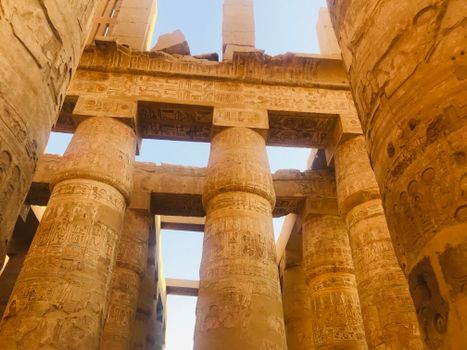 Intricate hieroglyphs on columns at the Karnak Temple in Luxor, Egypt.