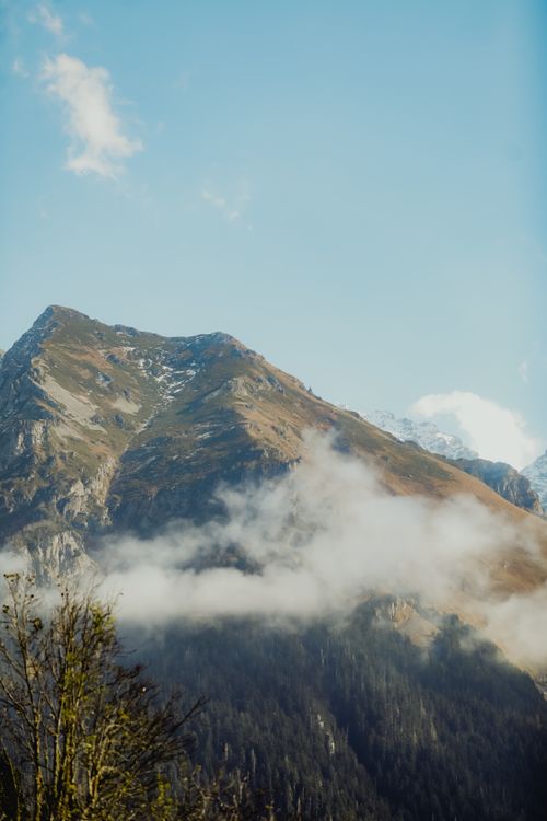 Free Stunning view of a mountain peak enveloped in clouds, against a clear sky. Stock Photo