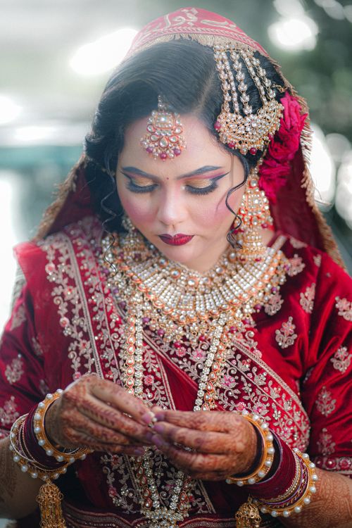 Free Stunning Indian bride in red, intricately embroidered traditional attire and jewelry. Stock Photo