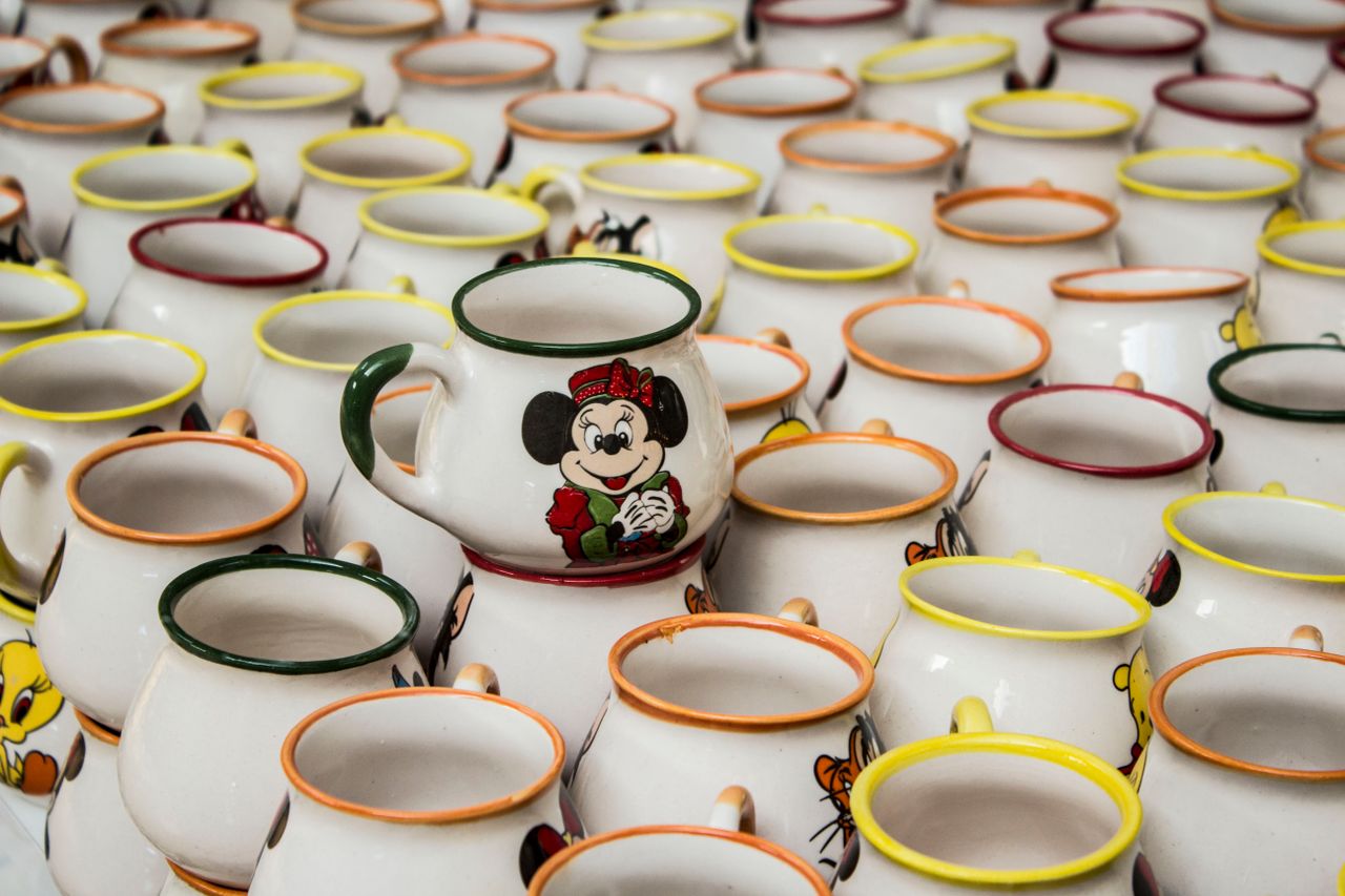 a collection of stacked ceramic mugs with cartoon characters in k tahy
