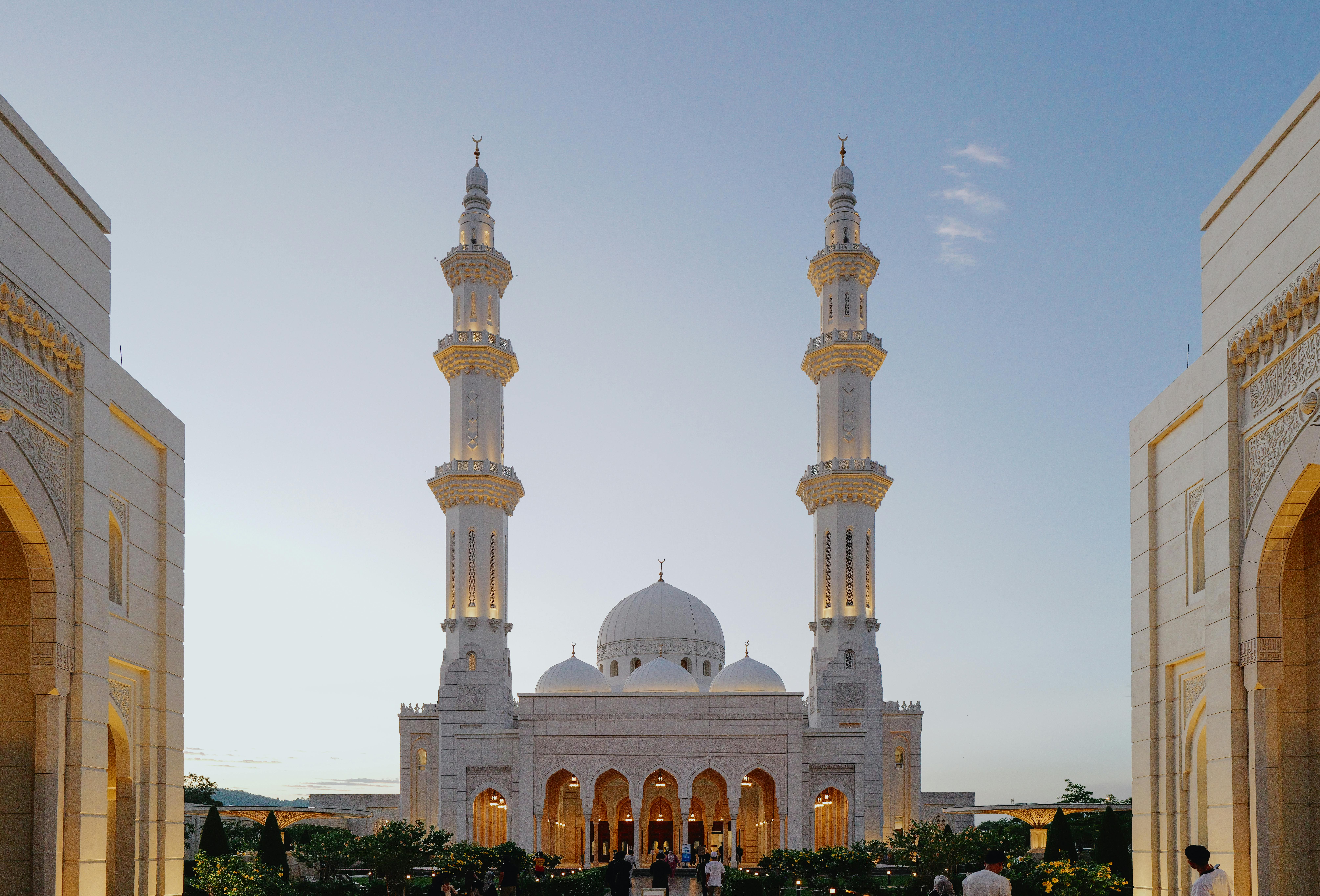 Beautiful view of the Sendayan Mosque with lit minarets at sunset, capturing Islamic architecture charm.