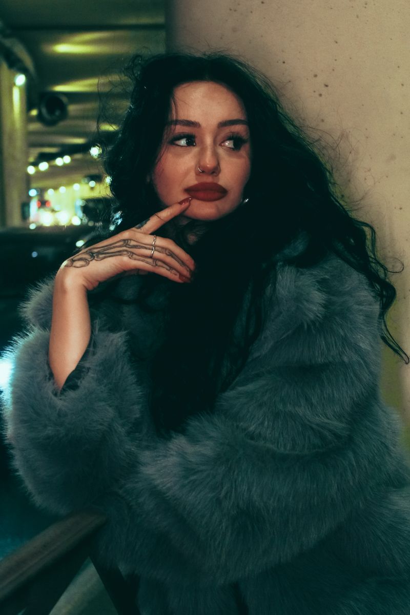 Elegant woman in fur coat at night in the city