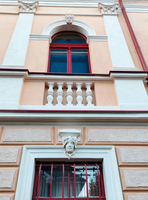 Free A detailed view of a historic building facade with decorative elements and symmetrical windows. Stock Photo