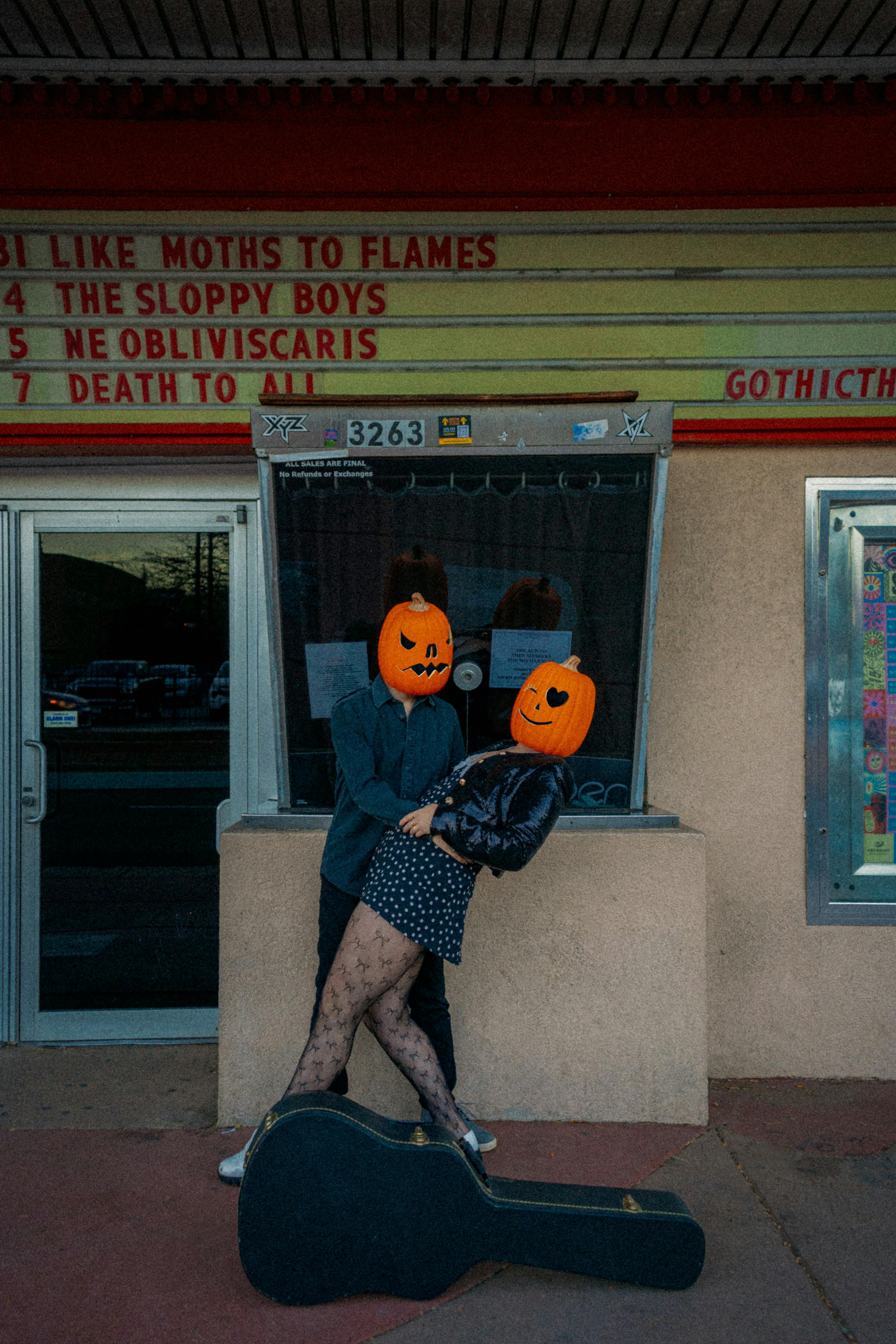 Kostenlos Ein verspieltes Pärchen mit Kürbisköpfen posiert vor einem Theater in Englewood und fängt so eine skurrile Halloween-Stimmung ein. Stock-Foto