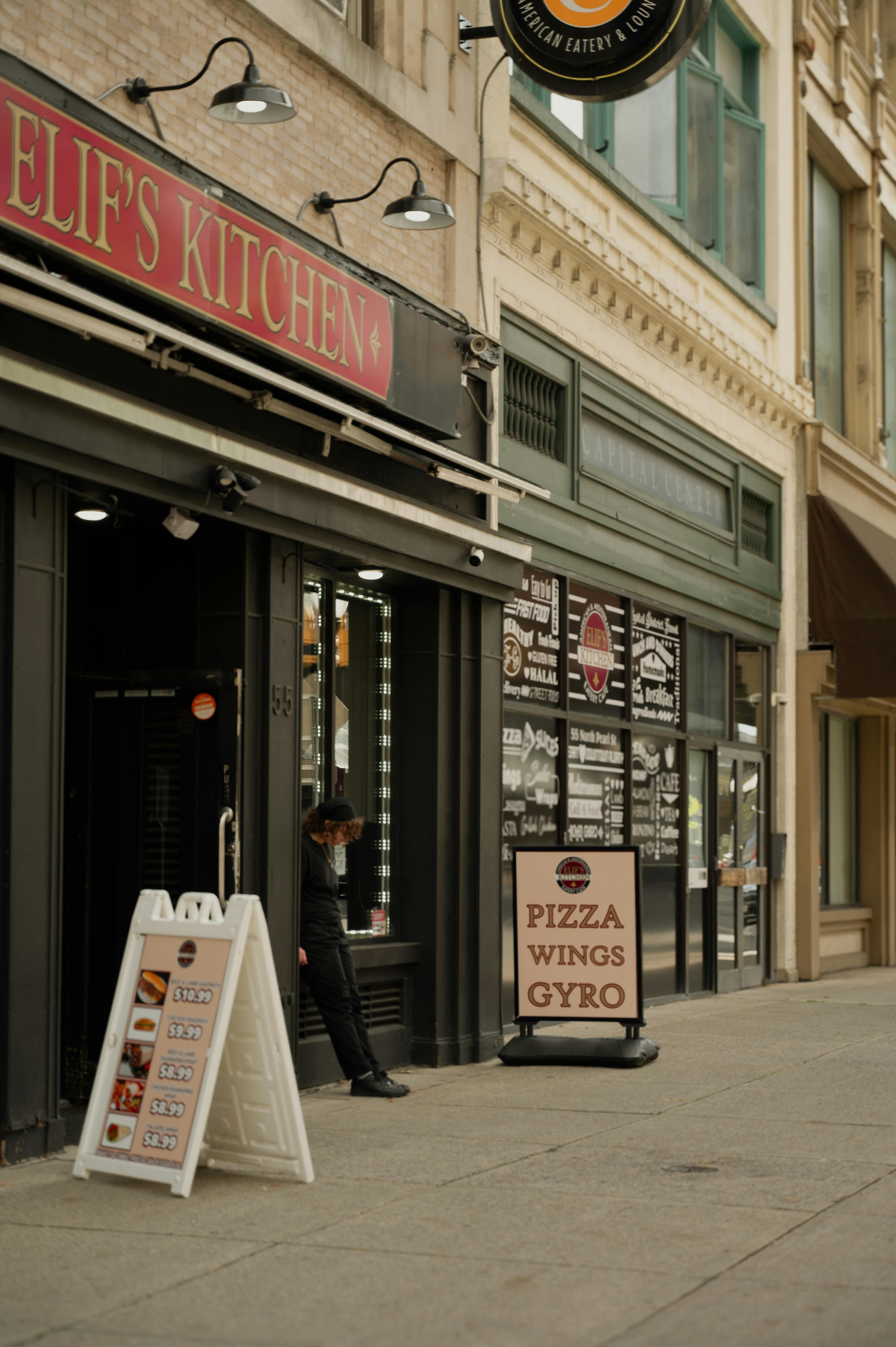 Street view of an urban eatery showcasing inviting entrance with vintage signs and cozy ambiance.