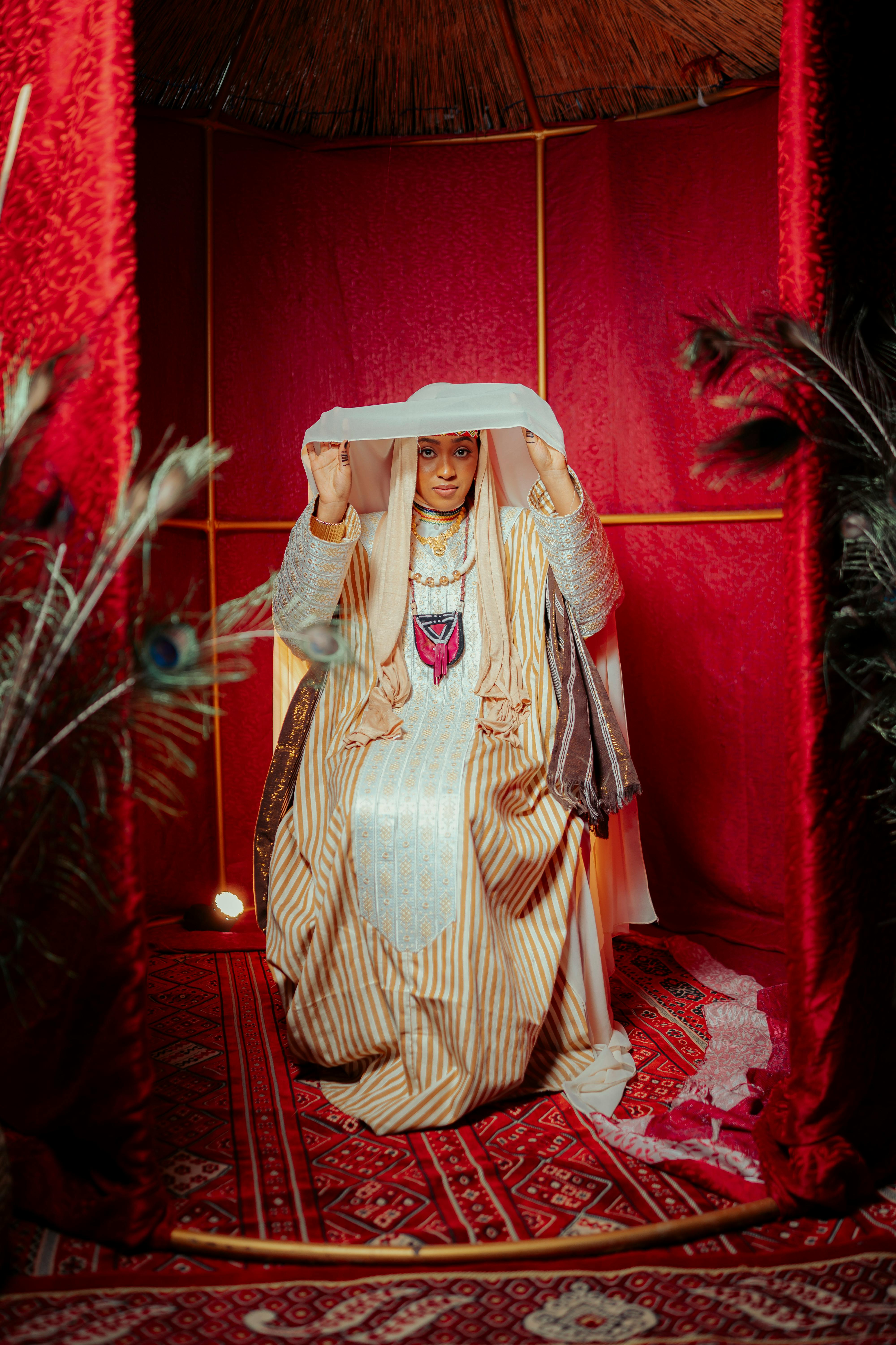 A woman wearing a traditional Middle Eastern bridal outfit in a vibrant setting.