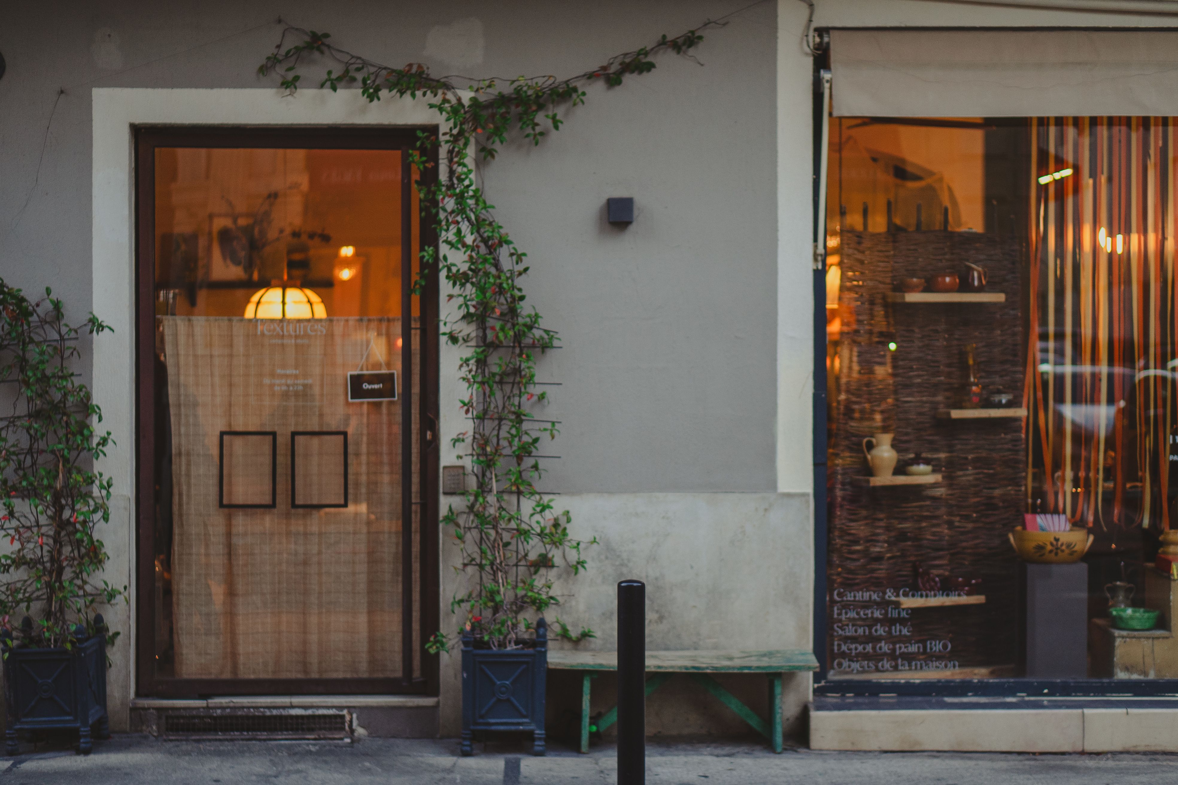 Elegant exterior of a French bistro in Nîmes, France, with inviting warm lighting.