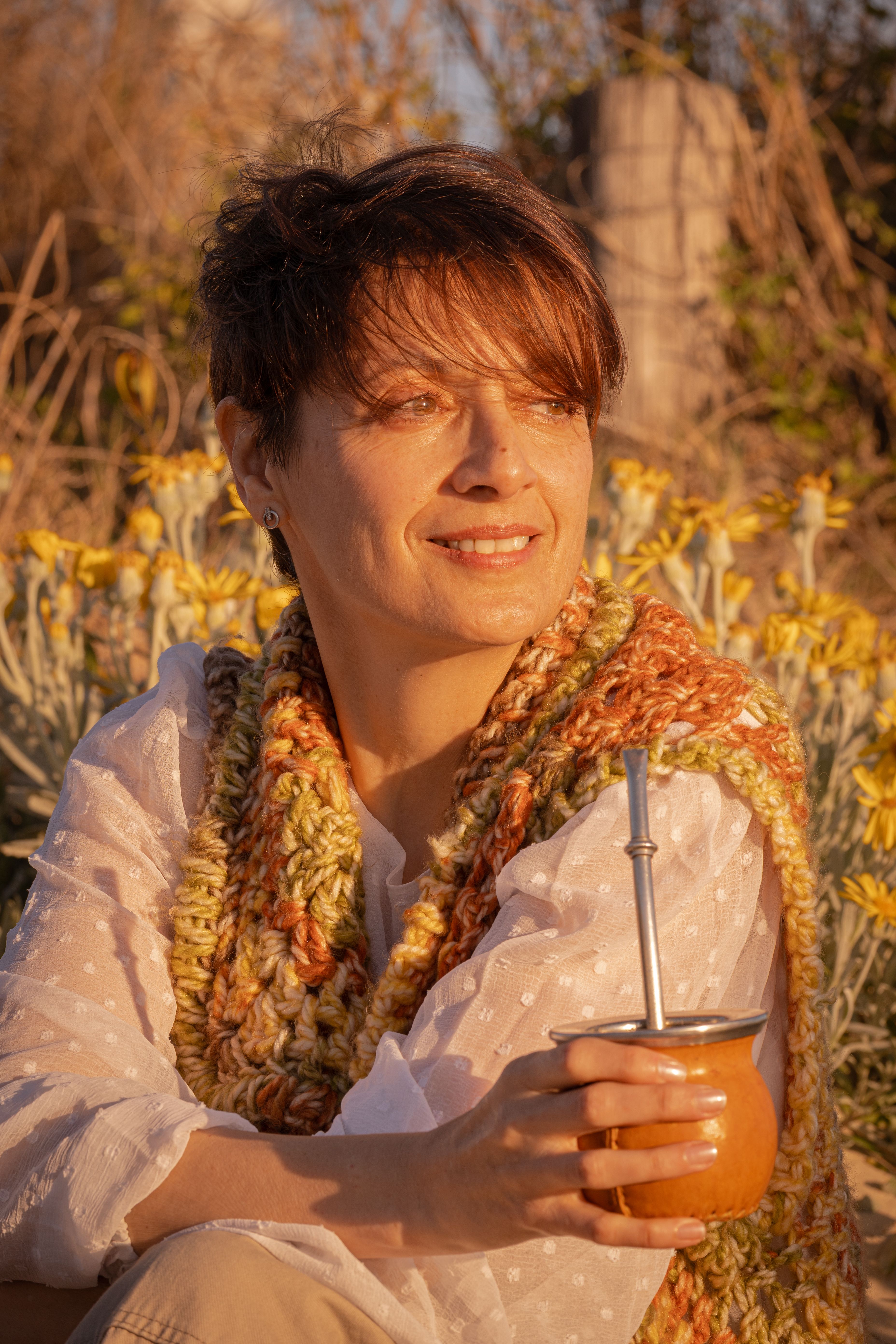 Smiling woman with mate cup in autumn setting, Montevideo.
