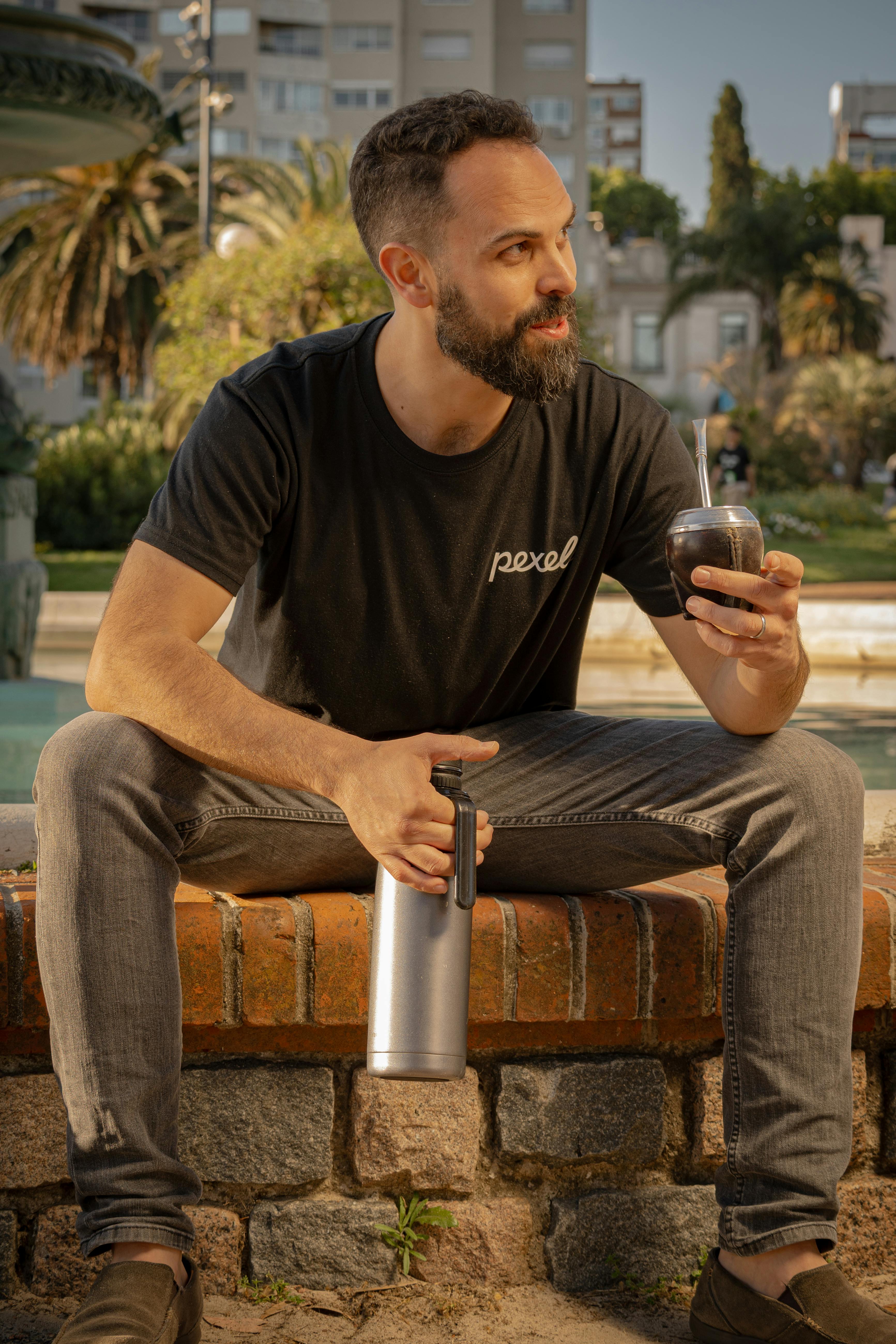 Man relaxing with Yerba Mate in Montevideo park, embodying Uruguayan culture.