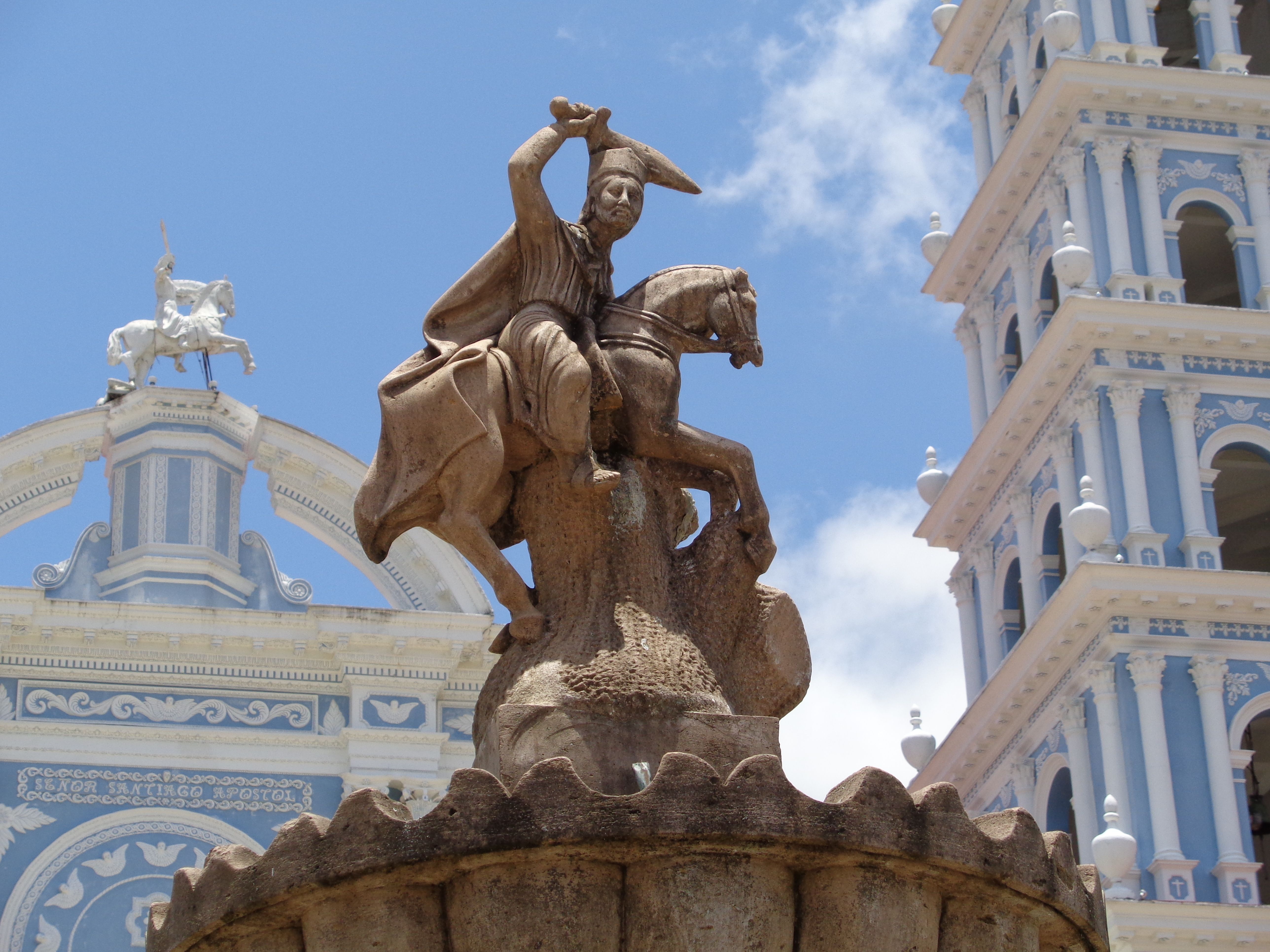 A dramatic statue of a warrior on horseback in front of a historic Catholic church in Ometepec, Mexico.