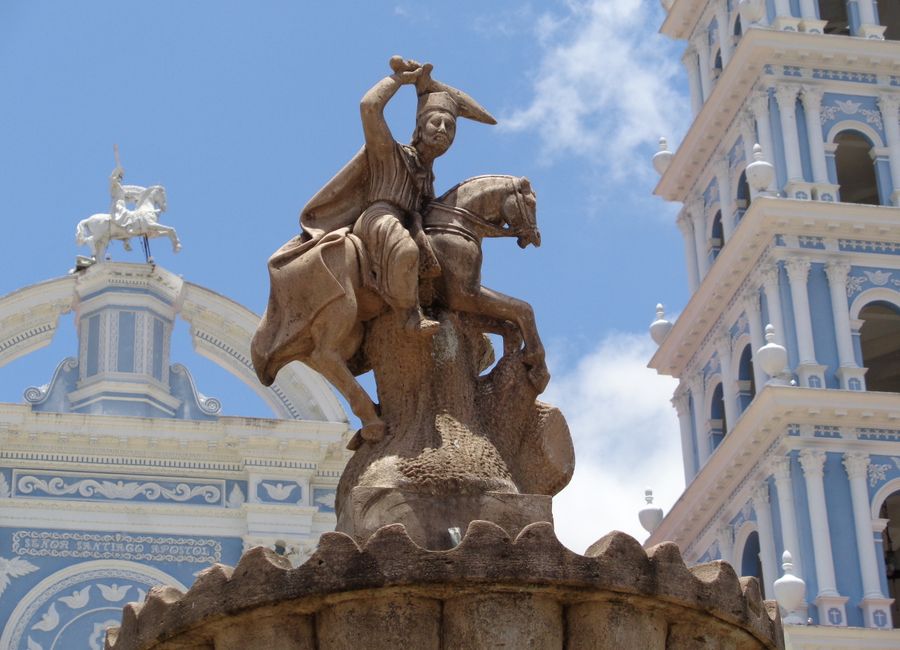 A dramatic statue of a warrior on horseback in front of a historic Catholic church in Ometepec, Mexico.