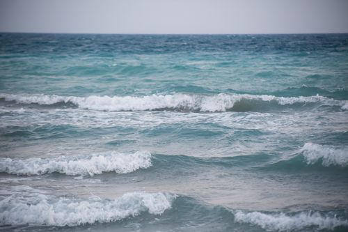 Free Peaceful view of ocean waves gently crashing on a calm sea day. Stock Photo