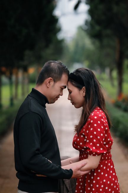 Fotomural Una pareja romántica comparte un momento íntimo en un parque exuberante, ilustrando el amor y la conexión.