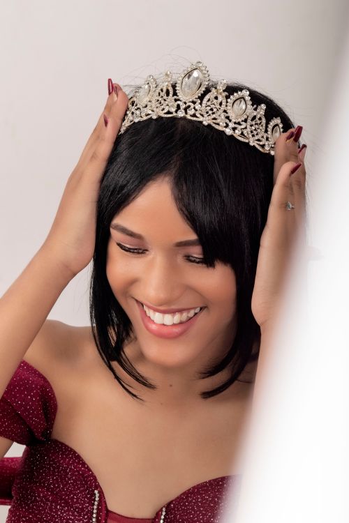 Free Charming quinceañera portrait featuring a young woman with a sparkling tiara. Stock Photo