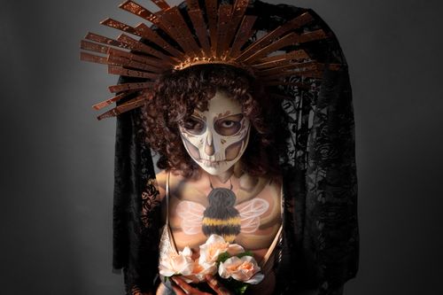 Free A striking portrait of a person with Day of the Dead face paint and floral headpiece. Stock Photo