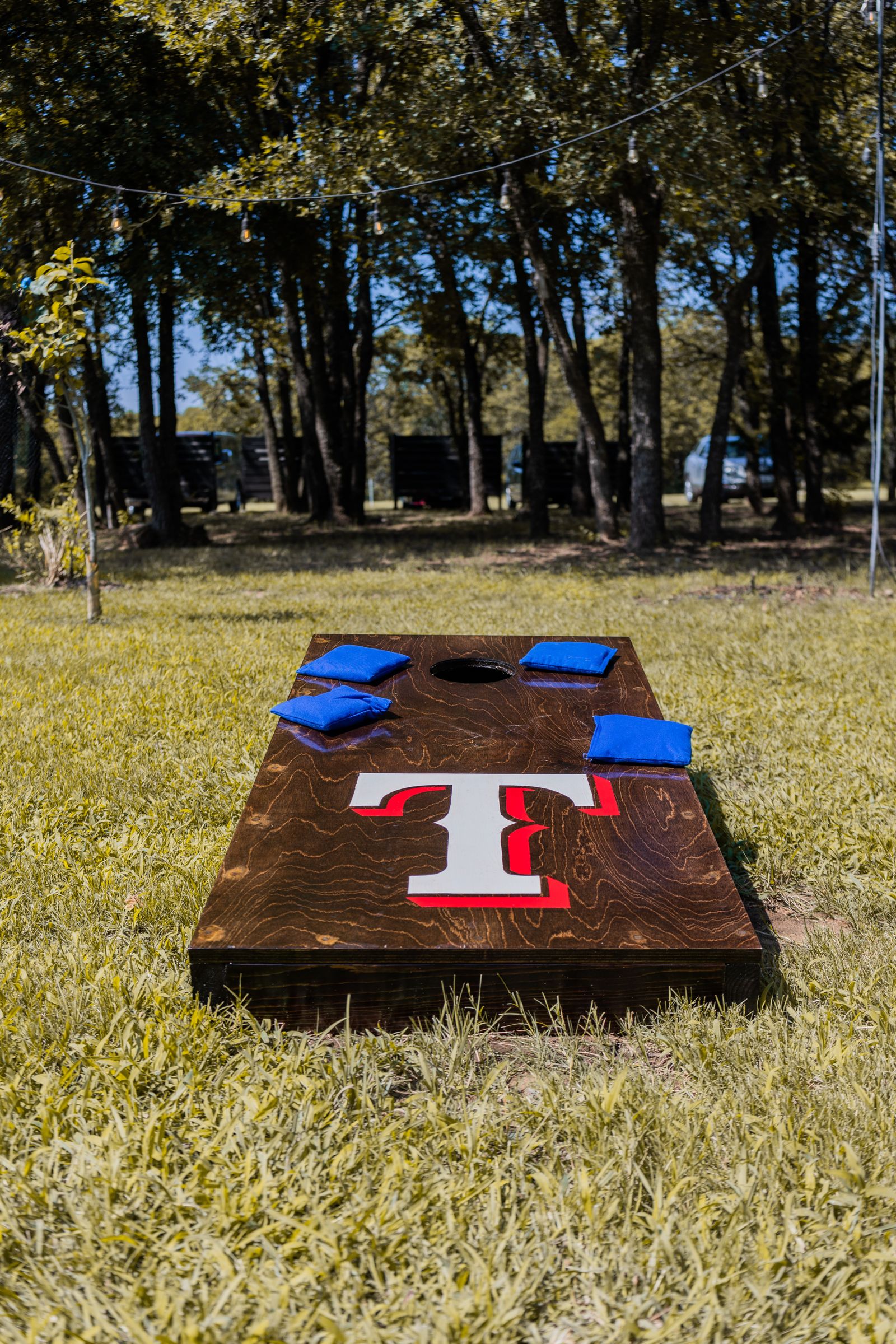 Cornhole wooden boards and beanbags arranged on a green lawn