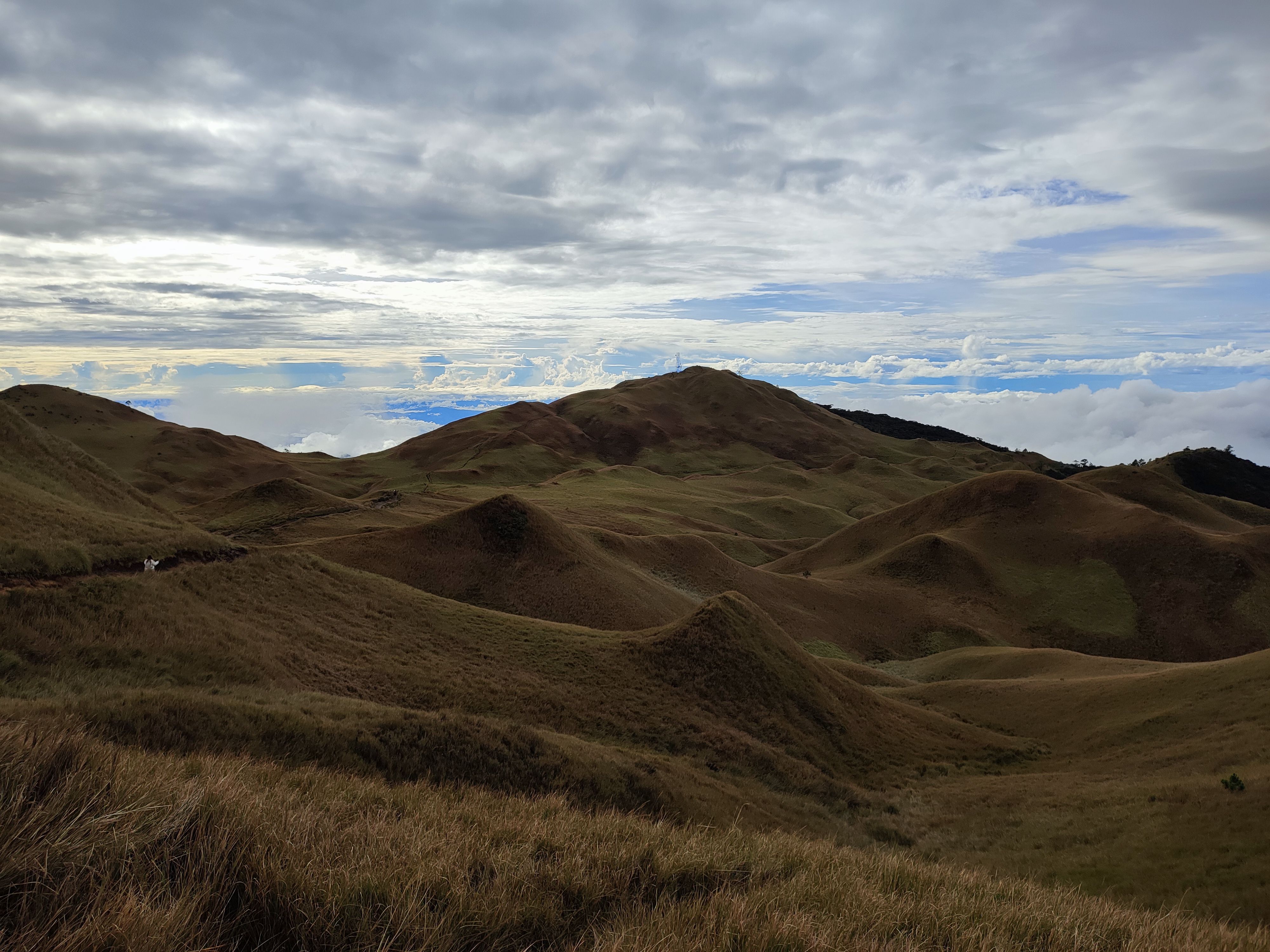 Panoramic view of rolling hills with dramatic cloud formations in the background.