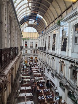 A vibrant indoor courtyard with classic architecture and dining tables.