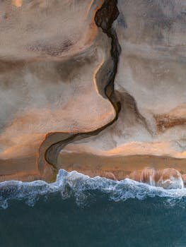 Captivating aerial view of Denmark's coastline at sunset, with stunning patterns and ocean waves.