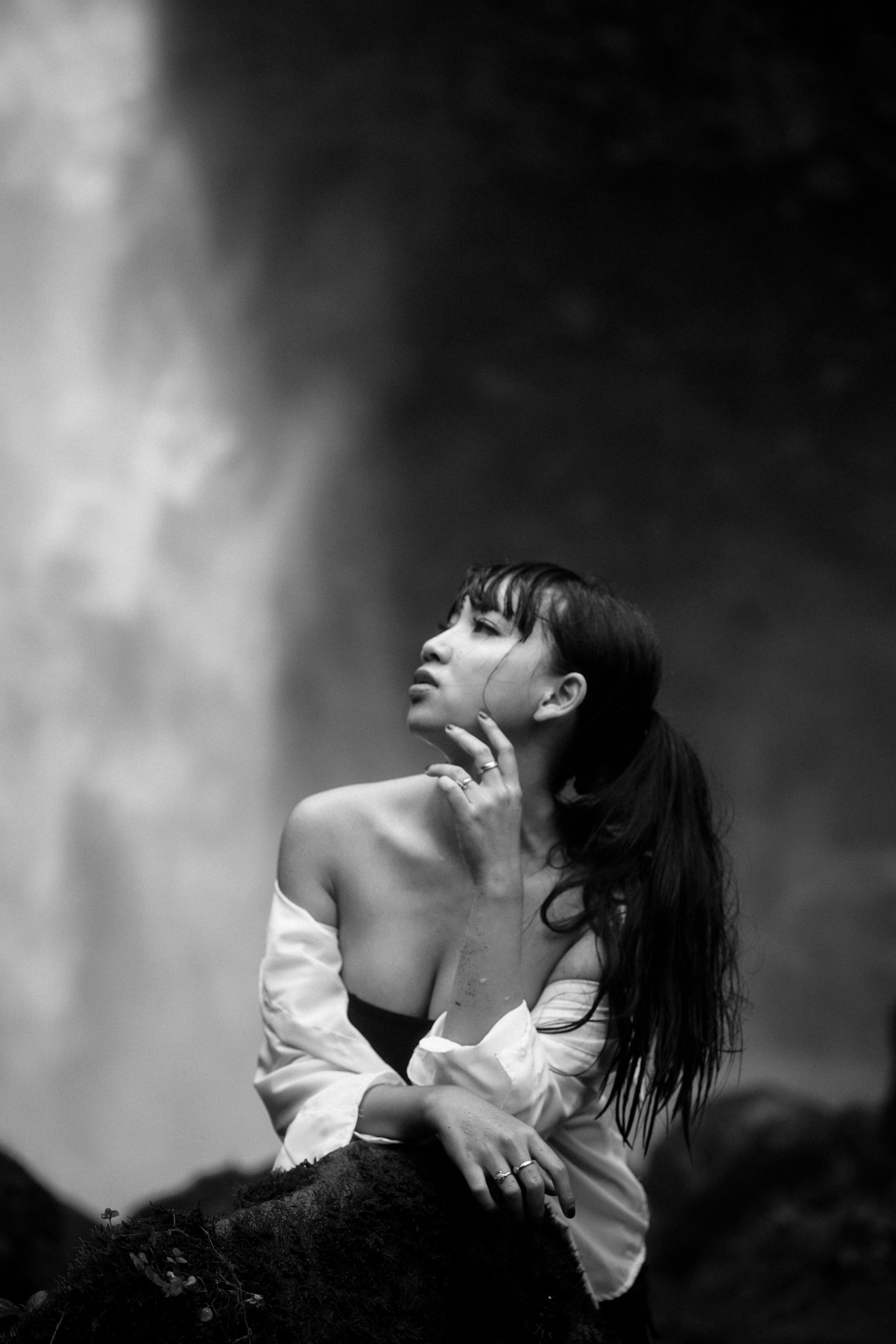 Elegant woman in nature by waterfall