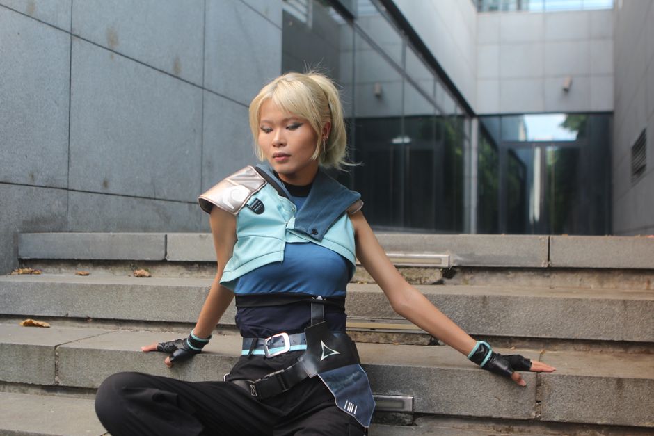 Model poses in futuristic attire on urban steps. Trendy and sleek fashion.