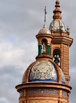 Close-up of ornate cathedral towers with intricate architecture and vibrant tiles under a cloudy sky.