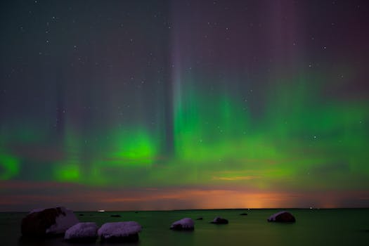 Capture of vivid Northern Lights reflecting over the serene Estonian coastline.