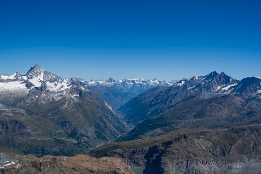 A stunning aerial view of the Swiss Alps with clear sky and majestic mountains.