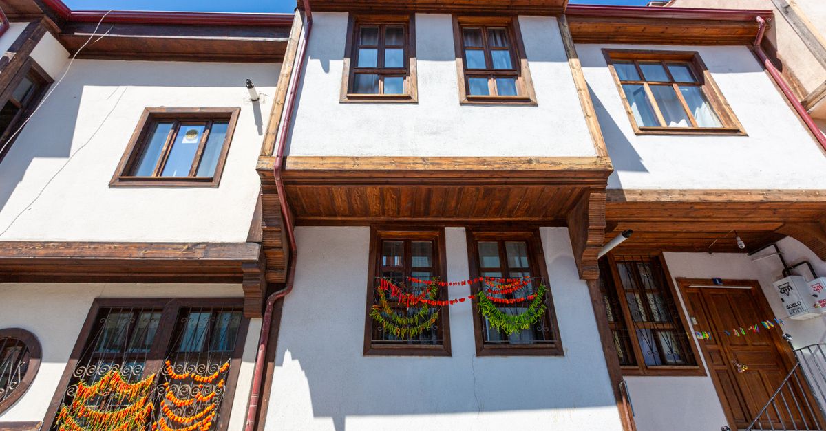 Beautiful Ottoman-style house facade with wooden accents under a clear blue sky.