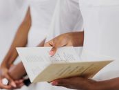 Close-up of a woman's hands holding a wedding ceremony program.