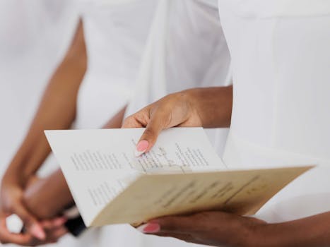 Close-up of a woman's hands holding a wedding ceremony program.