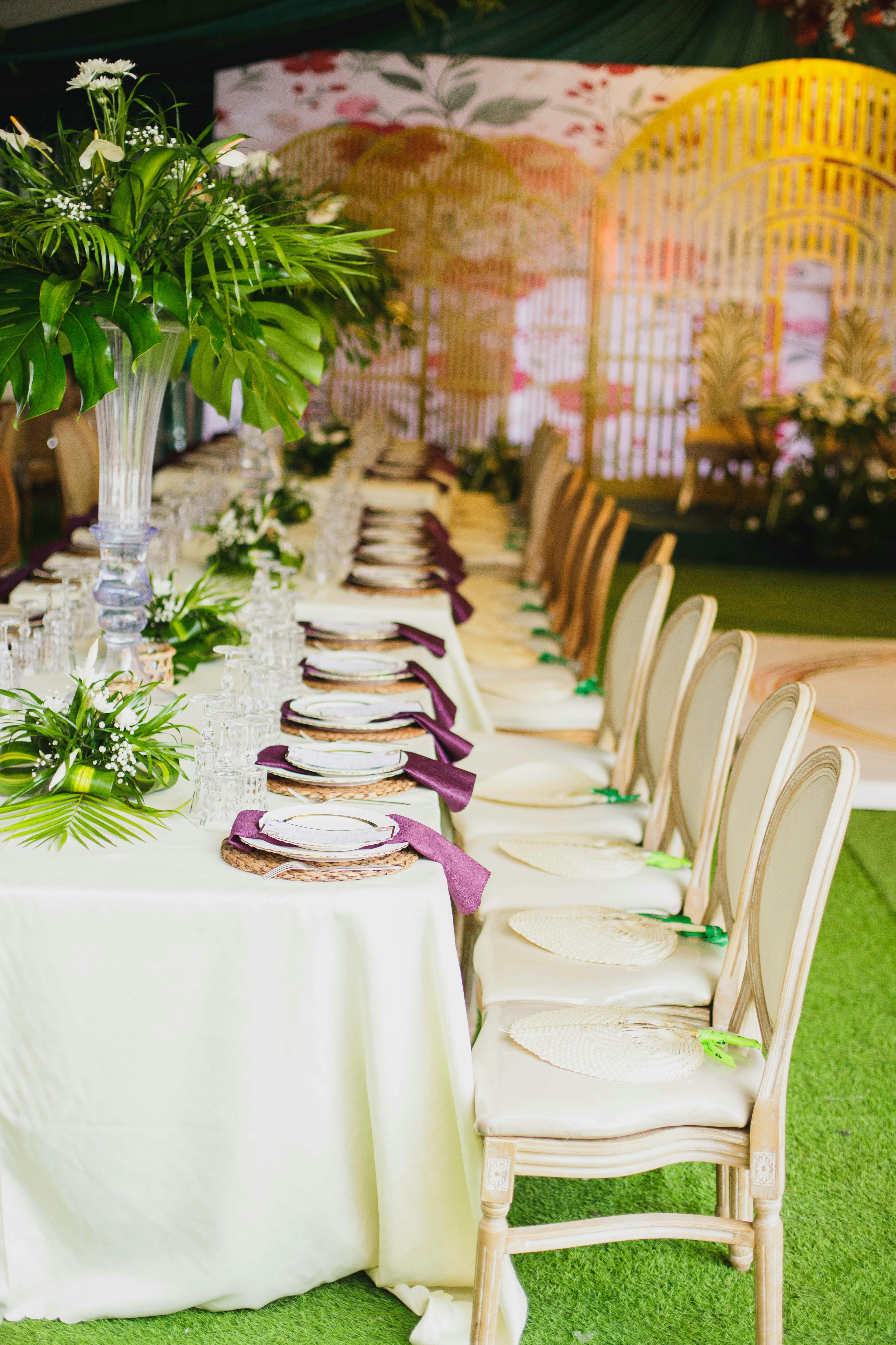 A beautifully decorated wedding reception table with elegant details and lush greenery.