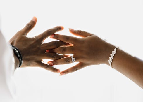 Elegantly styled hands wearing a ring and bracelet, symbolizing unity and commitment.