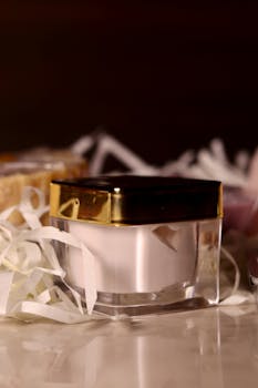 A close-up of a luxurious cream jar surrounded by elegant packaging materials.