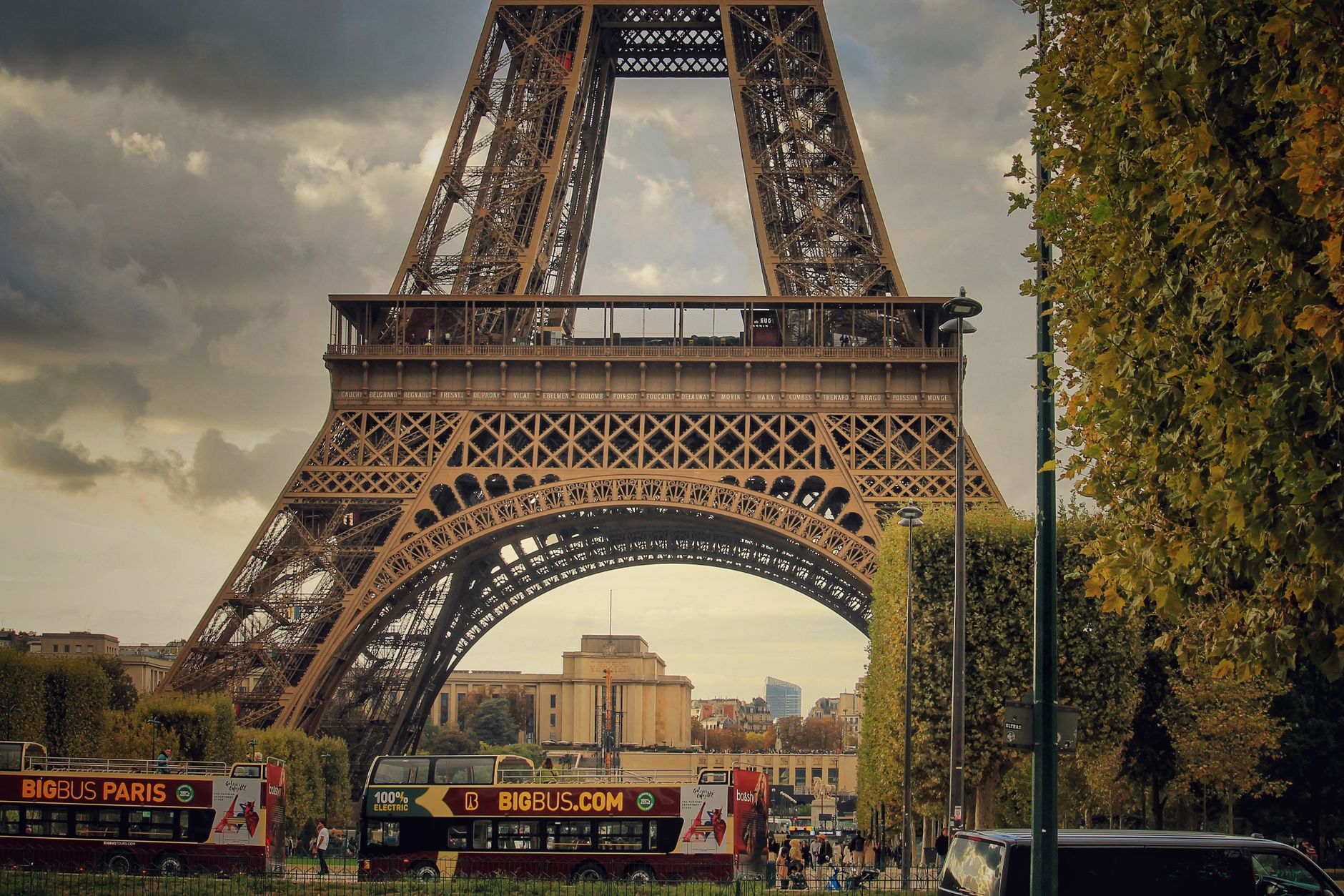 Captivating view of the Eiffel Tower amidst Parisian city life and sightseeing buses.