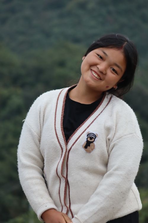 Free Young Asian woman smiling warmly outdoors, wearing a cozy white sweater. Stock Photo