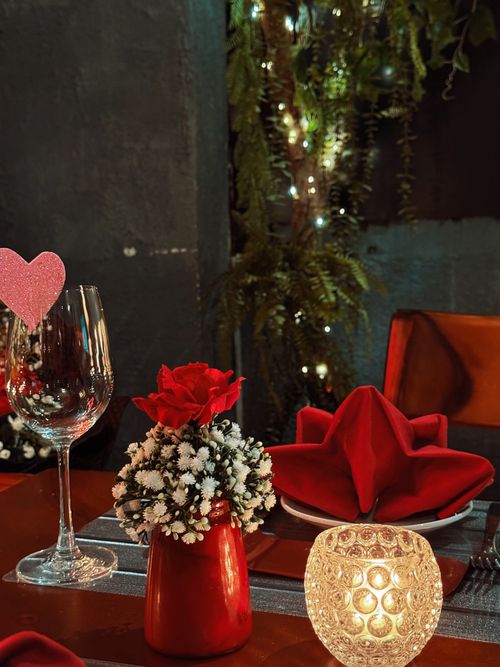 Free Elegant romantic dinner setting with red decorations and intimate lighting. Stock Photo